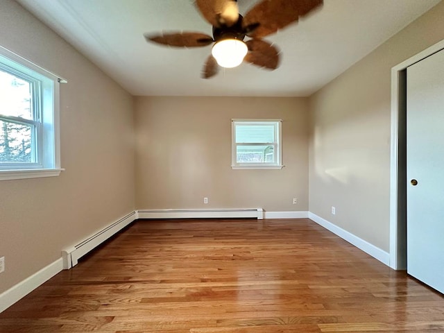 unfurnished room with light hardwood / wood-style flooring, ceiling fan, and baseboard heating