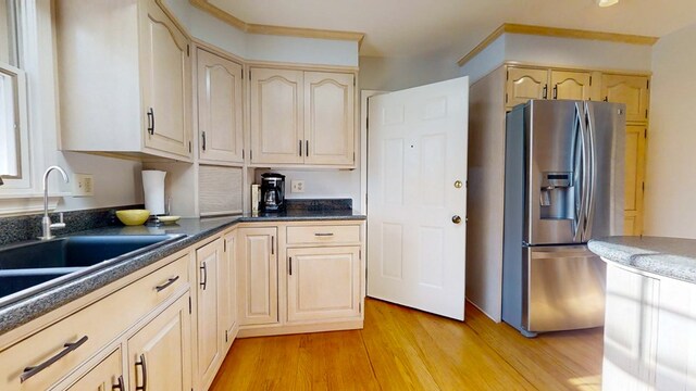 kitchen with stainless steel fridge, light hardwood / wood-style floors, sink, and light brown cabinets