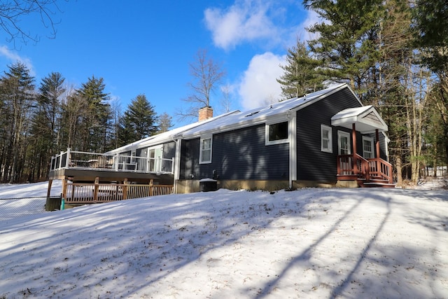 view of snow covered exterior with a wooden deck