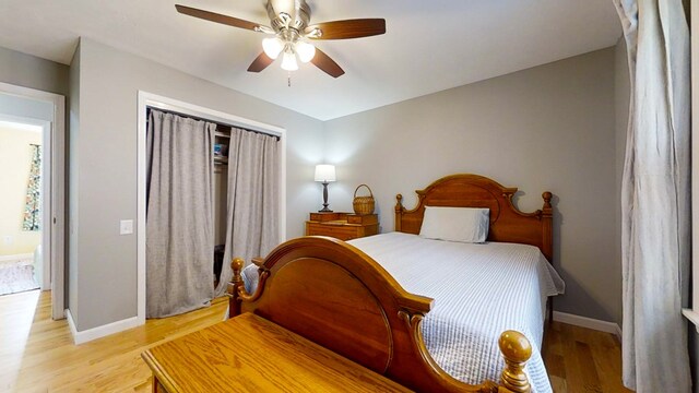 bedroom featuring ceiling fan, a closet, and light wood-type flooring