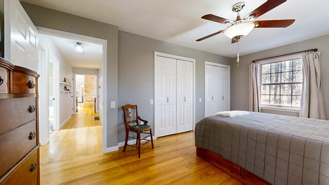 bedroom featuring multiple closets, ceiling fan, and light wood-type flooring