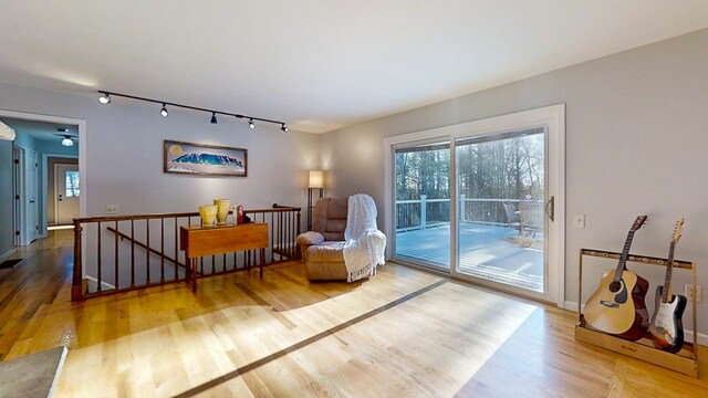 sitting room with wood-type flooring and track lighting