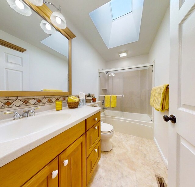 full bathroom featuring enclosed tub / shower combo, vanity, toilet, and a skylight