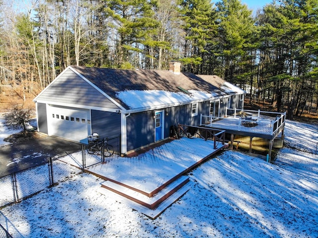 view of front facade with a garage, a wooden deck, and a sunroom