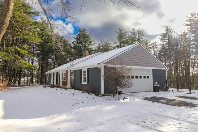 view of snowy exterior with a garage