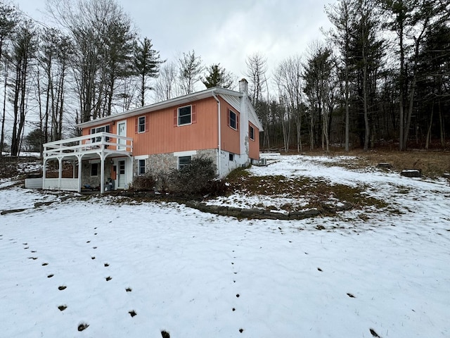 snow covered house featuring a balcony