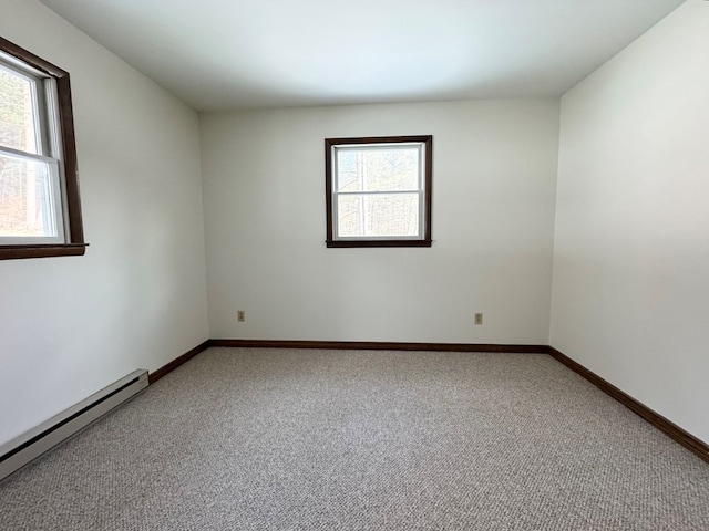 spare room with carpet flooring and a baseboard heating unit