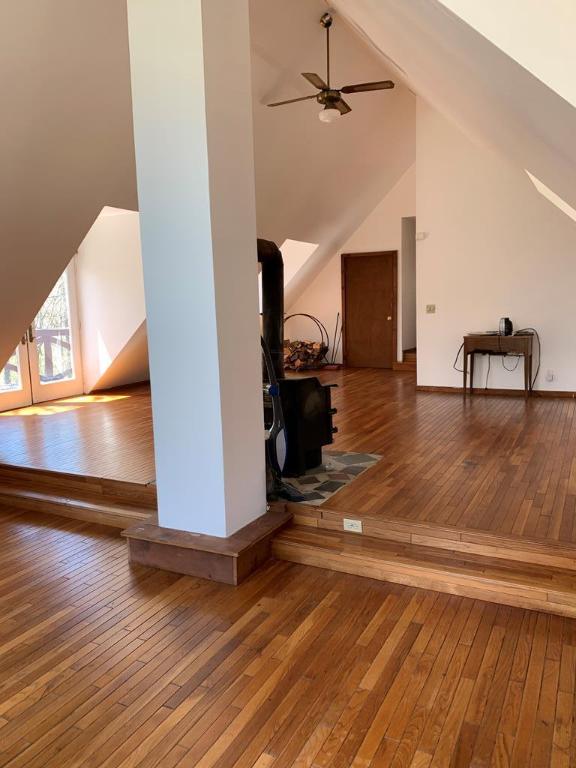 additional living space with hardwood / wood-style flooring, high vaulted ceiling, and ceiling fan