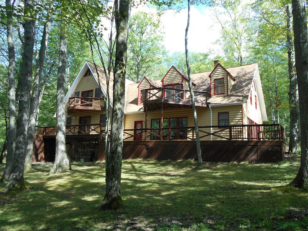 rear view of house featuring a yard and a deck