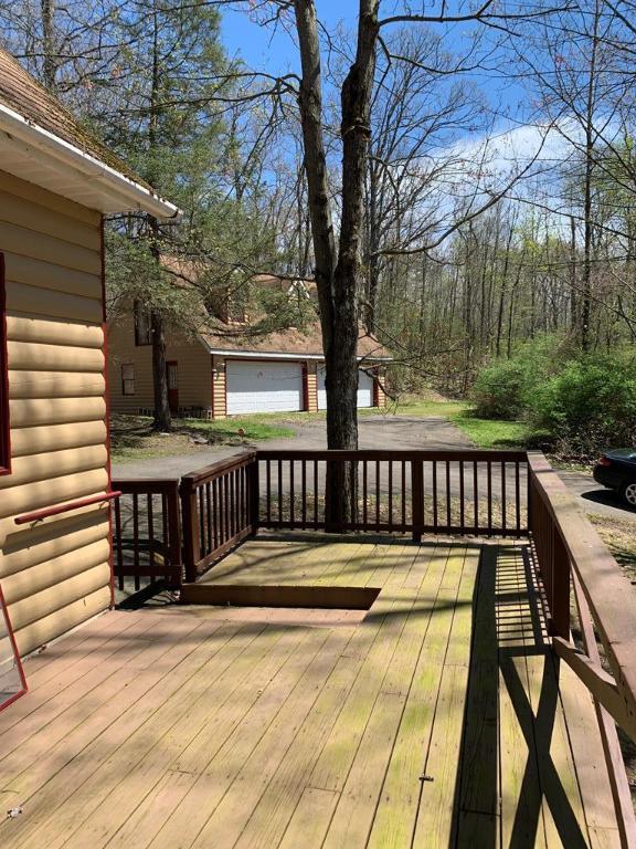 wooden deck with a garage and an outdoor structure