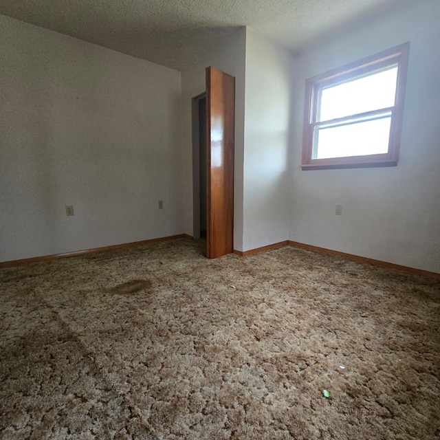 carpeted spare room featuring a textured ceiling