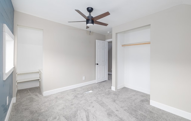 unfurnished bedroom featuring ceiling fan, light colored carpet, and a closet