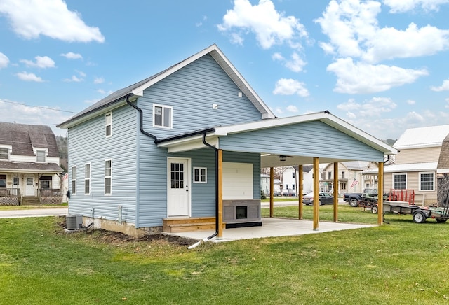 rear view of house featuring a patio area, central AC, and a lawn