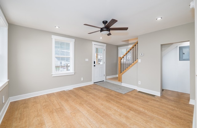 entrance foyer with electric panel, ceiling fan, and light hardwood / wood-style flooring