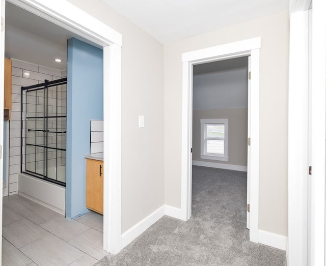 hallway featuring light colored carpet