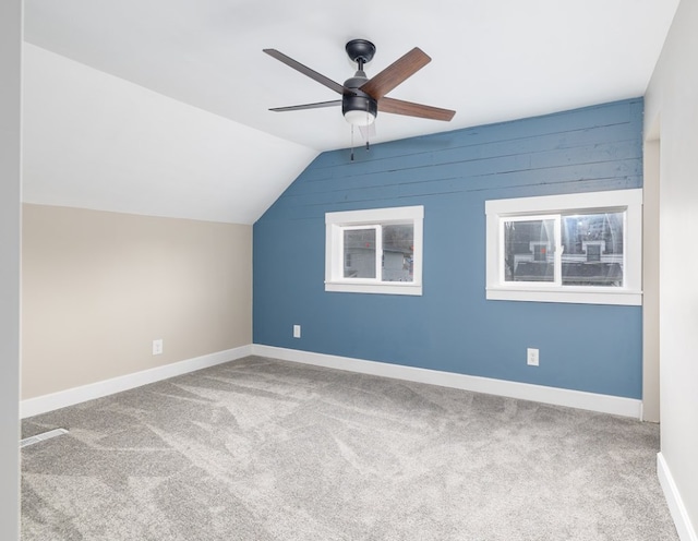 additional living space with lofted ceiling, light colored carpet, and ceiling fan