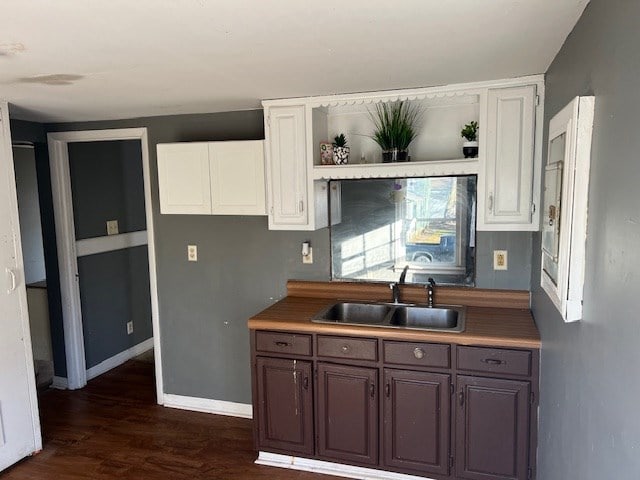 kitchen with white cabinetry, dark brown cabinets, sink, and dark hardwood / wood-style floors