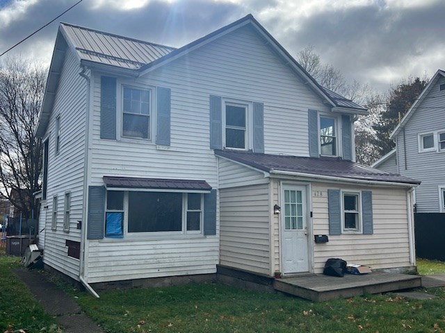 rear view of property featuring a yard