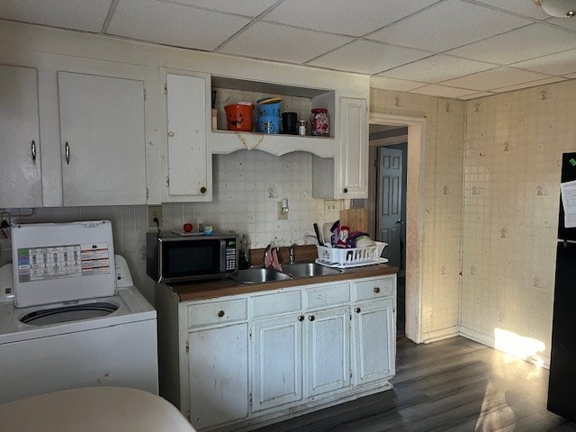 kitchen featuring white cabinetry, sink, washer / dryer, and a paneled ceiling