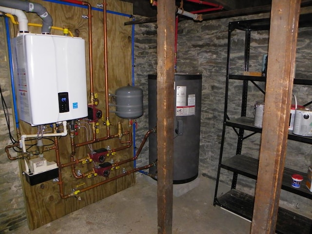 utility room with tankless water heater and electric water heater