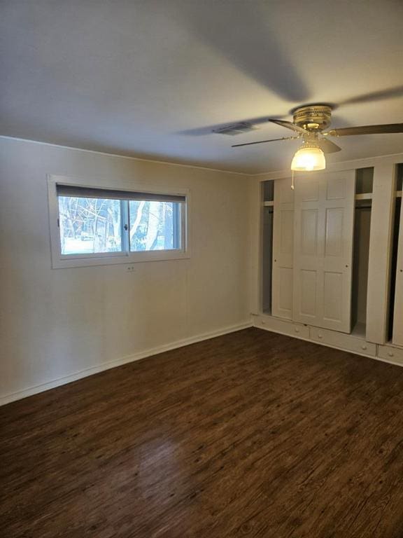 unfurnished bedroom with dark hardwood / wood-style flooring and ceiling fan