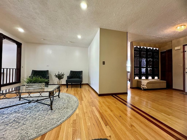 living room featuring a textured ceiling and light hardwood / wood-style flooring