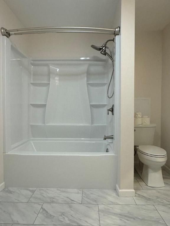 bathroom with bathing tub / shower combination and toilet