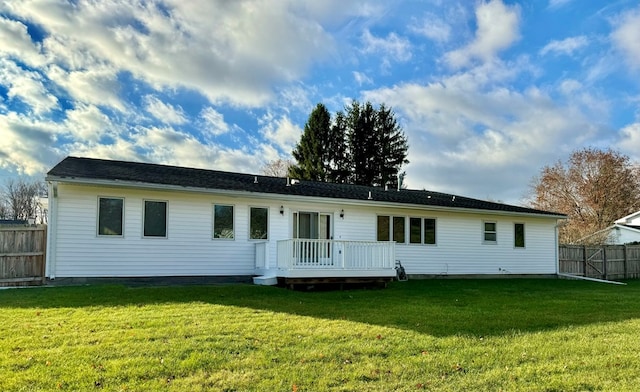 rear view of house with a yard and a deck