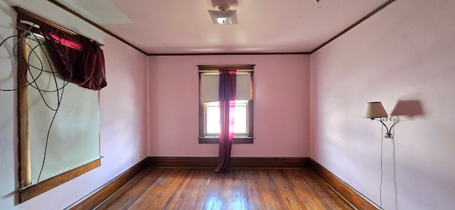 empty room with crown molding and dark hardwood / wood-style floors