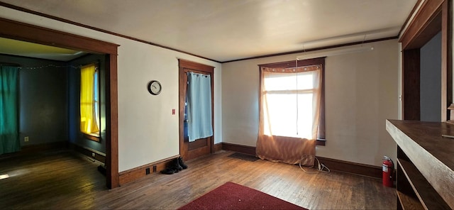 interior space with ornamental molding and dark hardwood / wood-style floors