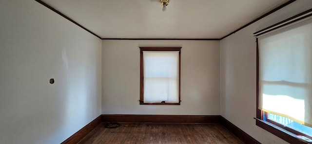 empty room with ornamental molding and dark wood-type flooring