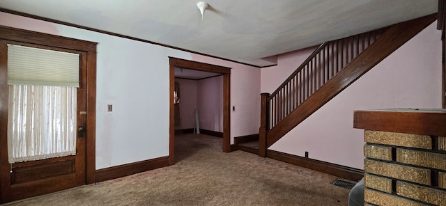 carpeted entrance foyer with ornamental molding