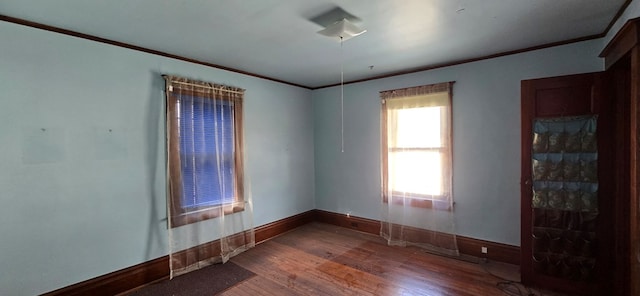 spare room featuring crown molding and hardwood / wood-style floors