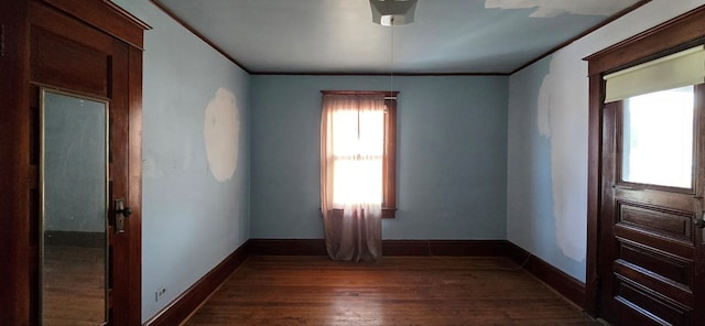 spare room with ornamental molding and dark hardwood / wood-style flooring