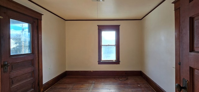 spare room with ornamental molding and dark wood-type flooring