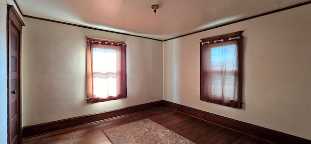 empty room featuring crown molding and dark hardwood / wood-style flooring