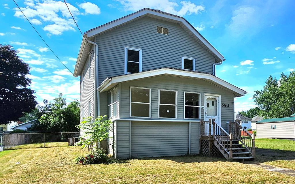 back of property featuring a yard