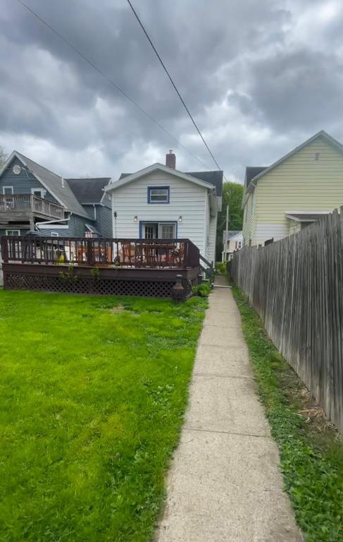 back of property featuring a wooden deck and a yard