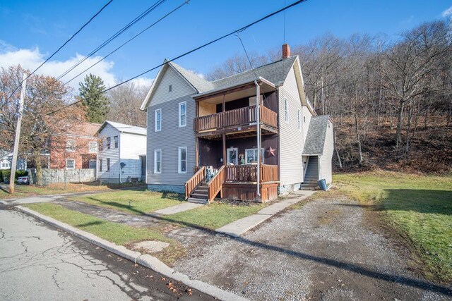 view of front of house with a front lawn and a balcony