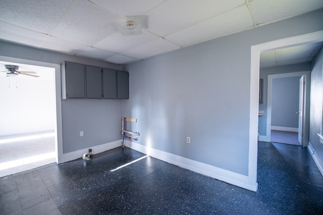 interior space with a drop ceiling and ceiling fan