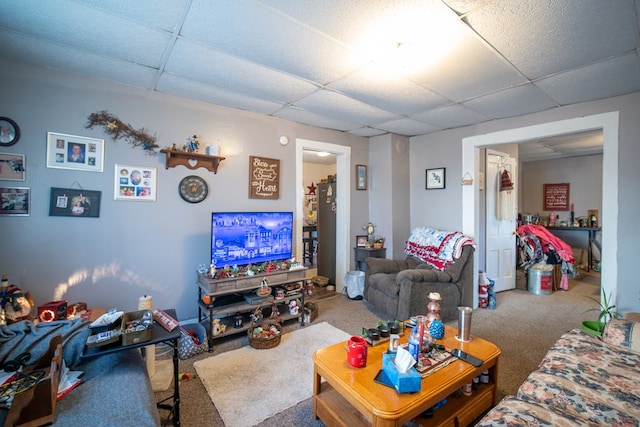 carpeted living room featuring a drop ceiling