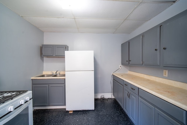 kitchen featuring sink, a paneled ceiling, and white appliances