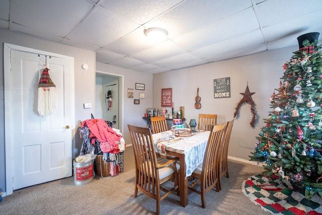 dining area featuring carpet and a paneled ceiling