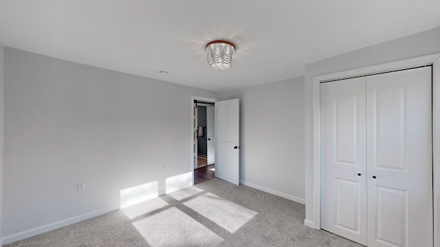 unfurnished bedroom featuring light carpet and a closet