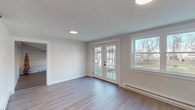 interior space with light hardwood / wood-style flooring, a baseboard radiator, and french doors