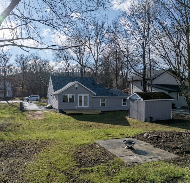 rear view of property featuring a yard and a storage unit