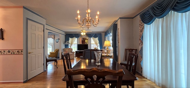 dining space featuring ceiling fan with notable chandelier, ornamental molding, and hardwood / wood-style floors