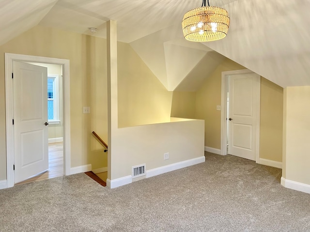 bonus room featuring vaulted ceiling, carpet flooring, and a chandelier