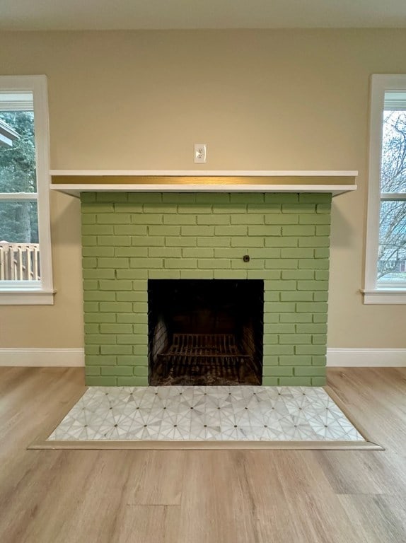 interior details with wood-type flooring and a brick fireplace