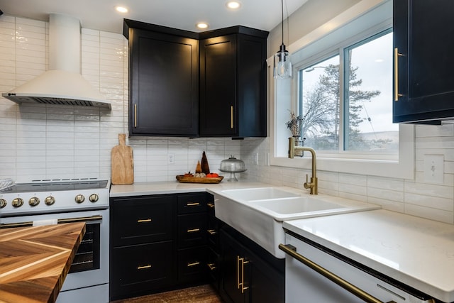 kitchen featuring wall chimney exhaust hood, tasteful backsplash, decorative light fixtures, dishwasher, and stove